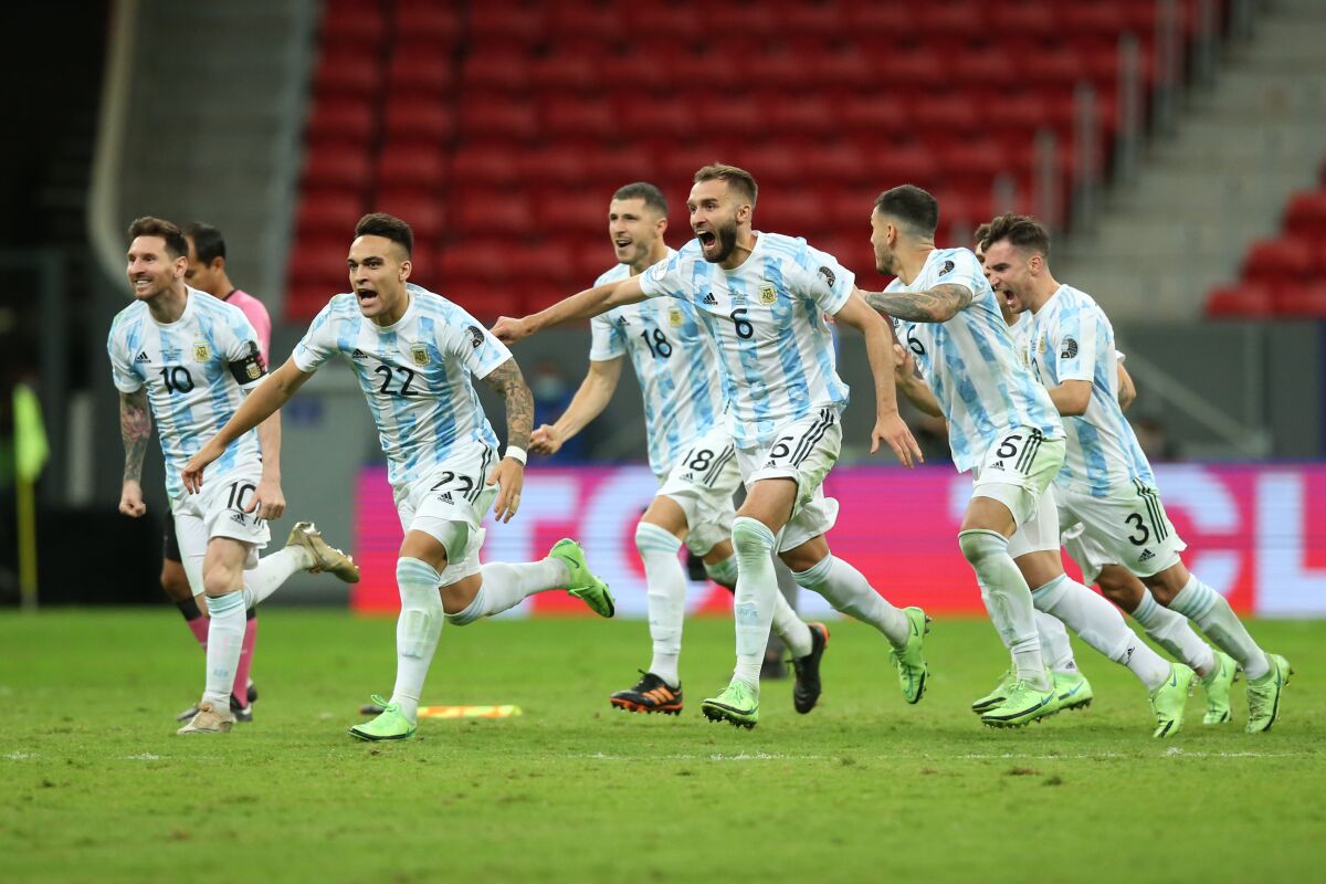Argentine players celebrate with teammates after winning a penalty shootout