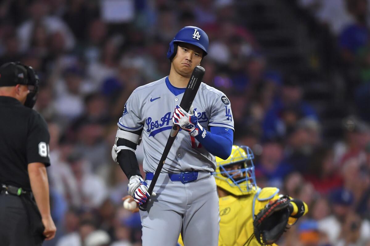 La estrella de los Dodgers, Shohei Ohtani, examina su bate antes de golpear en la cuarta entrada el sábado.