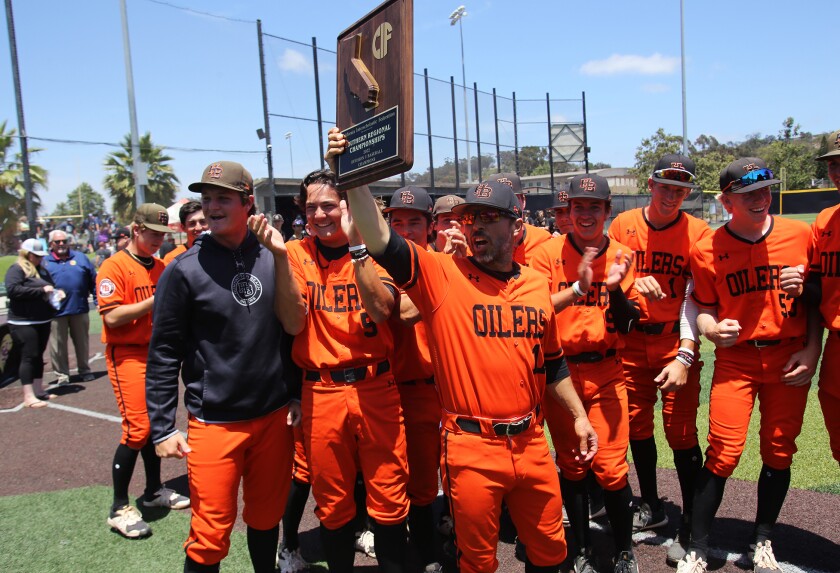 Huntington Beach head coach Benji Medure holds the CIF championship plaque as he celebrates with his team Saturday.