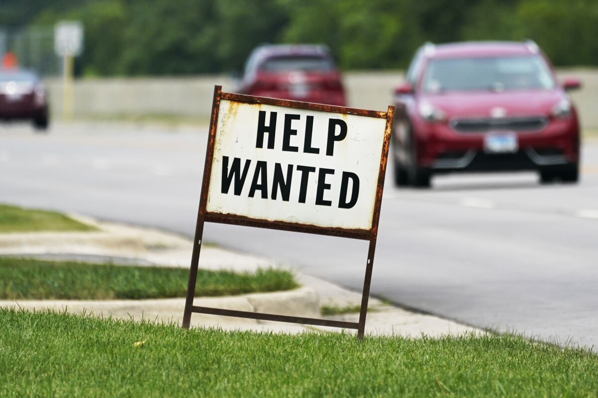 A help wanted sign is displayed at a gas station in Mount Prospect, Ill., Tuesday, July 27, 2021. The number of Americans applying for unemployment benefits fell last week by 14,000 to 385,000, Thursday, Aug. 5, more evidence that the economy and the job market are rebounding briskly from the coronavirus recession.(AP Photo/Nam Y. Huh)