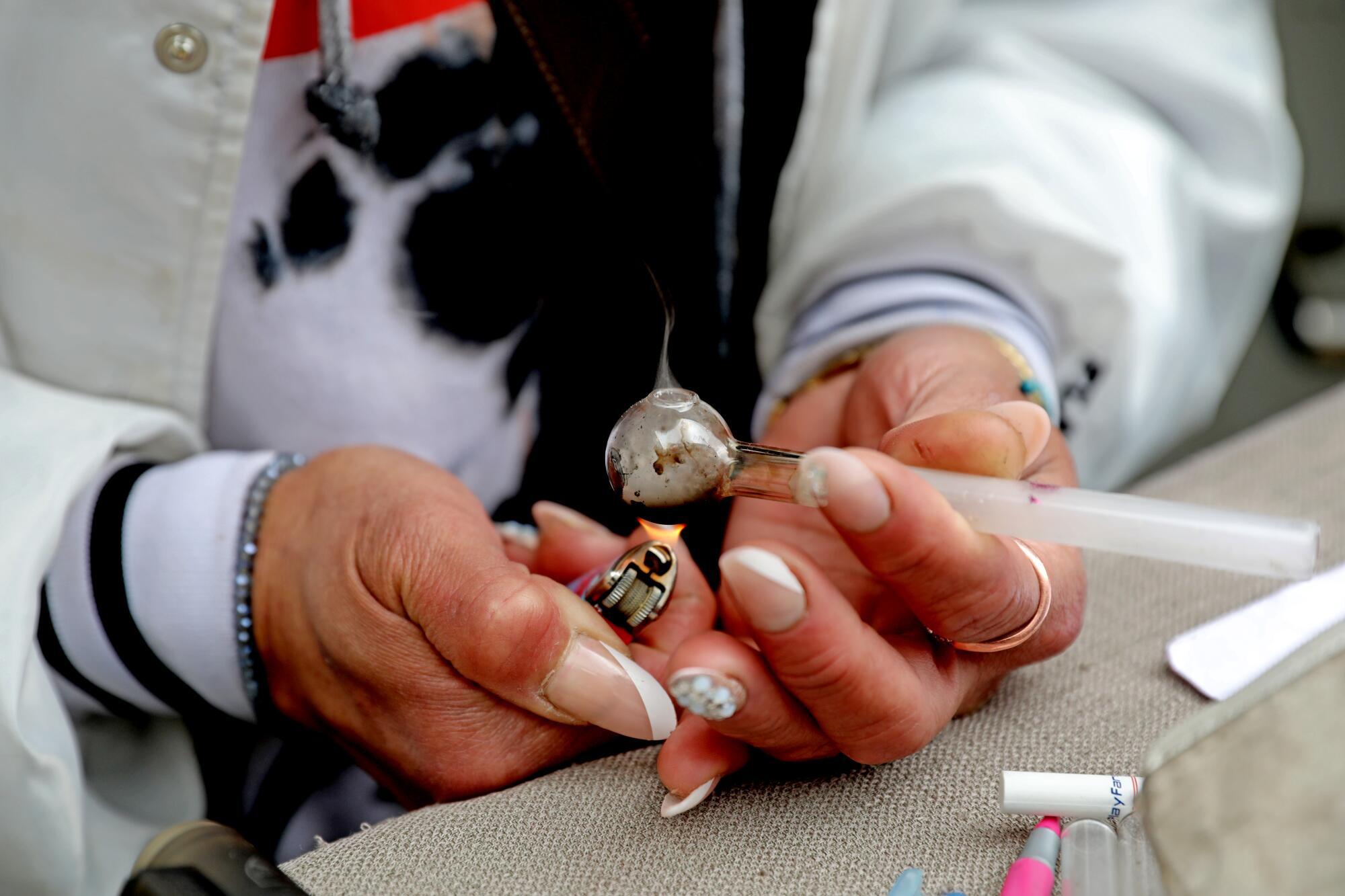 A woman holds drug paraphernalia