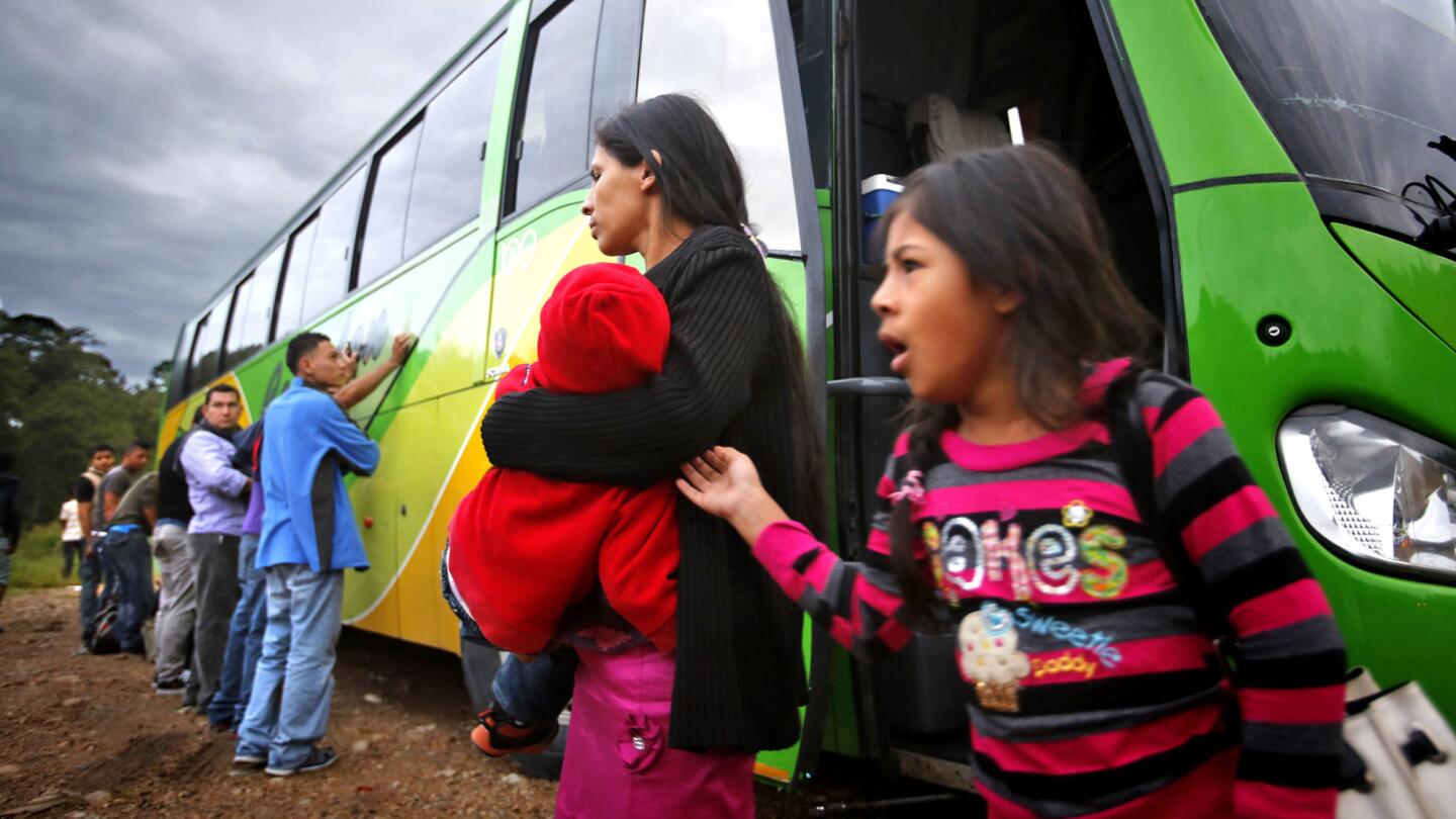 At dawn on July 4, a mother and her sleepy children get off a bus at a checkpoint in Ocotepeque, Honduras, a few miles south of the border with Guatemala. An elite force of American-trained police stopped the bus and searched for parents with children heading to the U.S.