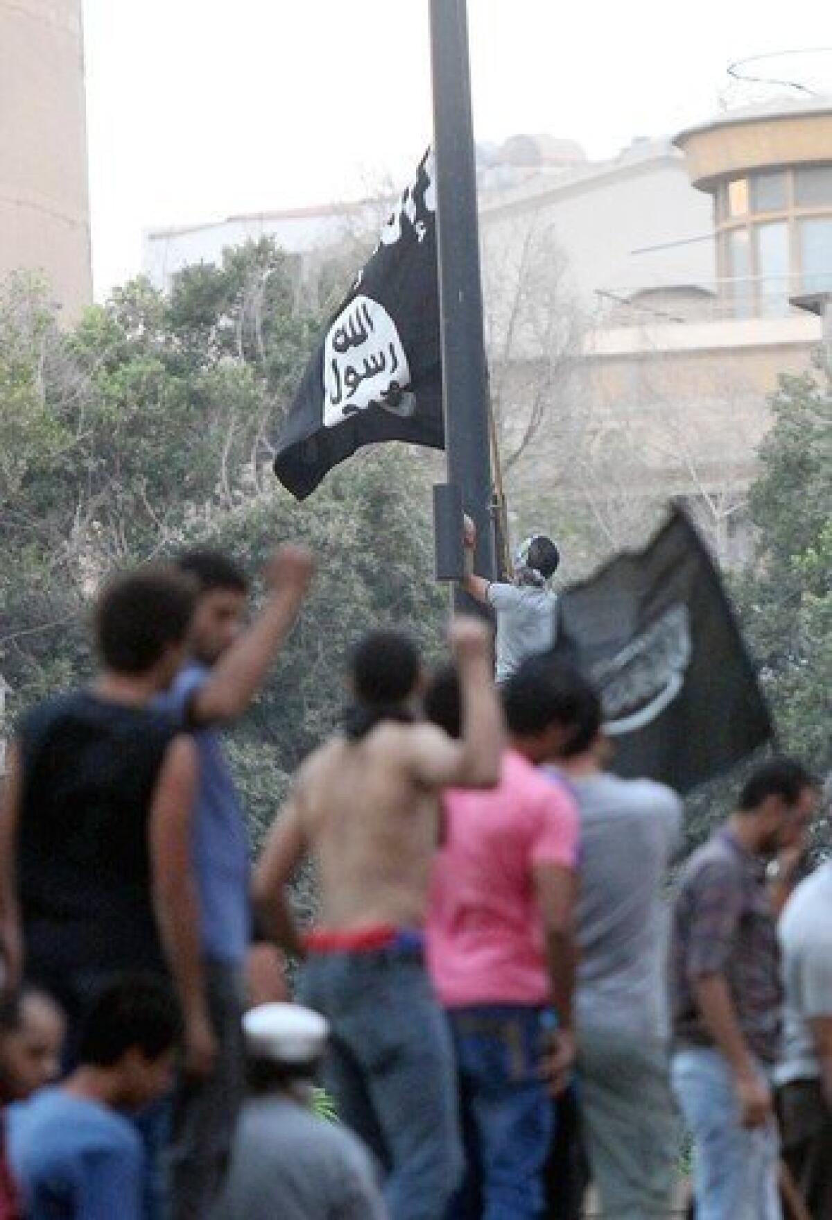 An Egyptian protester tries to raise an Islamic flag at the U.S. embassy during a protest, in Cairo, Egypt on September 11, 2012.