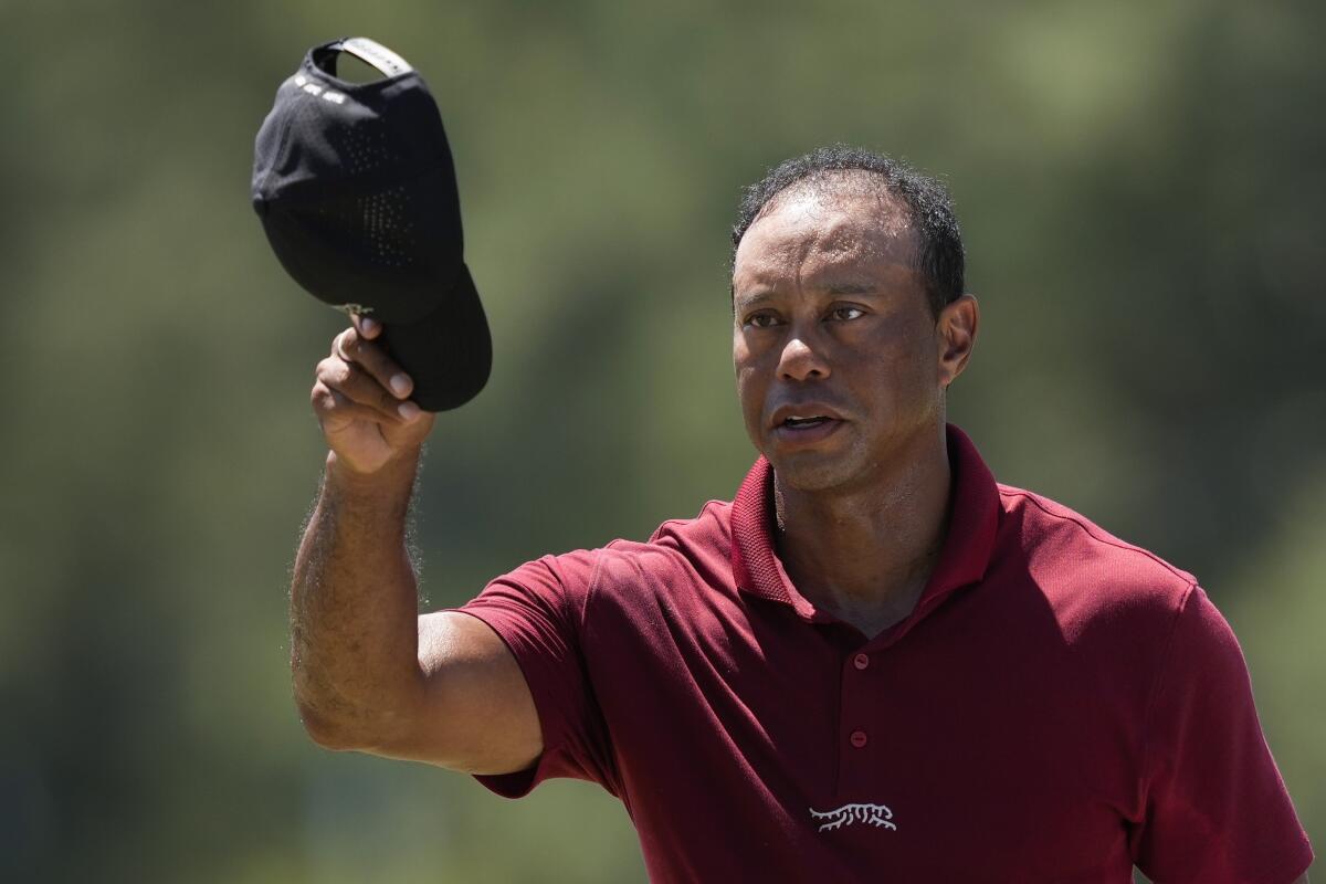 Tiger Woods tips his cap to spectators.