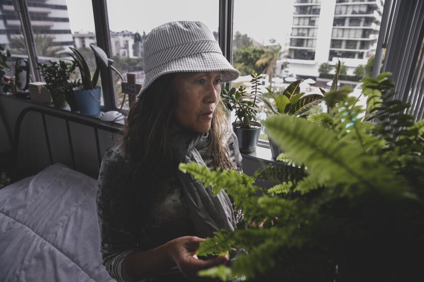 Los Angeles, CA - May 15: Josette Rojas tends to her plants at Barrington Plaza where owners have served the residents of 577 occupied rent-controlled units with eviction notices on Monday, May 15, 2023 in Los Angeles, CA. (Jason Armond / Los Angeles Times)