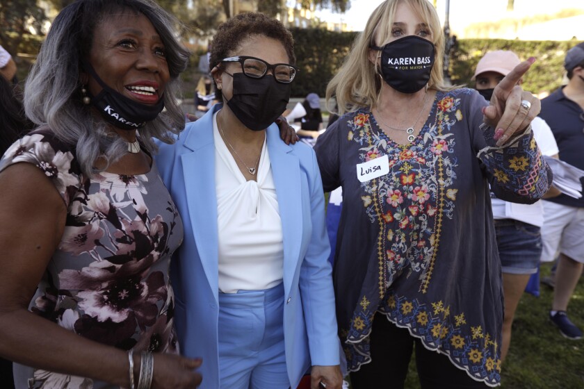 La representante Karen Bass, centro, pasa tiempo con votantes y voluntarios recogiendo firmas.