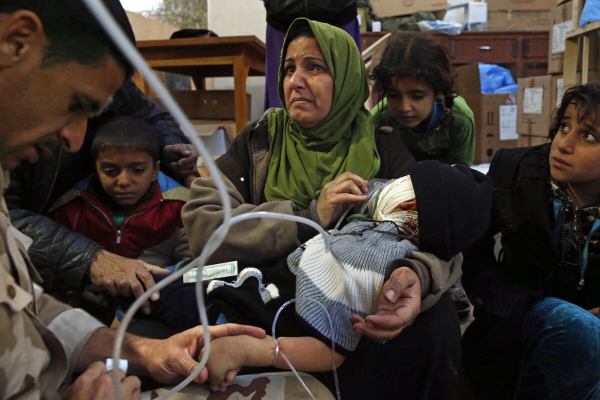 Wafa Abdel Raza, 39, holds her son Mahmoud Setar, 4, as the doctors give him oxygen and and fluids. The boy's head was badly injured when a truck bomb exploded near their home.