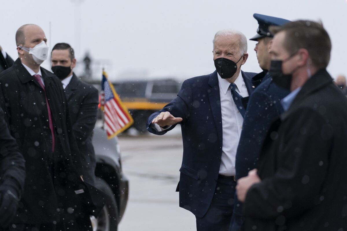 President Biden gestures as he boards Air Force One to make his way to Washington.