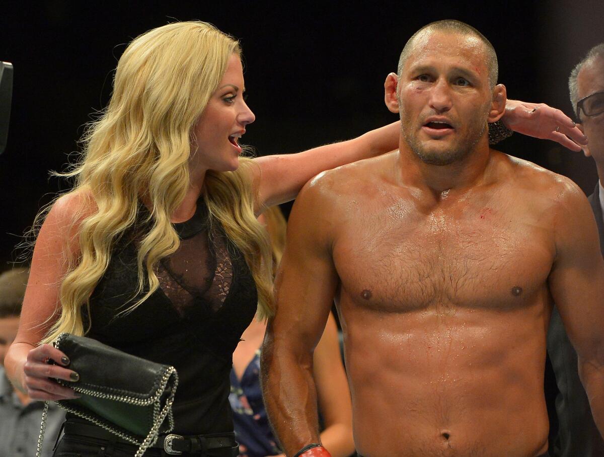 Dan Henderson exits the cage with his wife, Rachel Malter, after winning a middleweight bout against Hector Lombard by TKO in the second round at UFC 199 on June 4 at the Forum.
