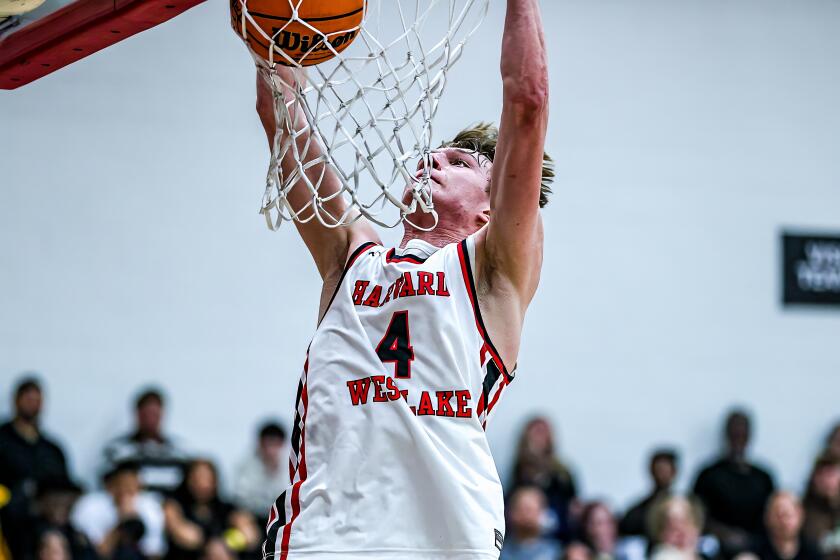 Nikolas Khamenia of Harvard-Westlake gets physical for a dunk in win over Crespi.