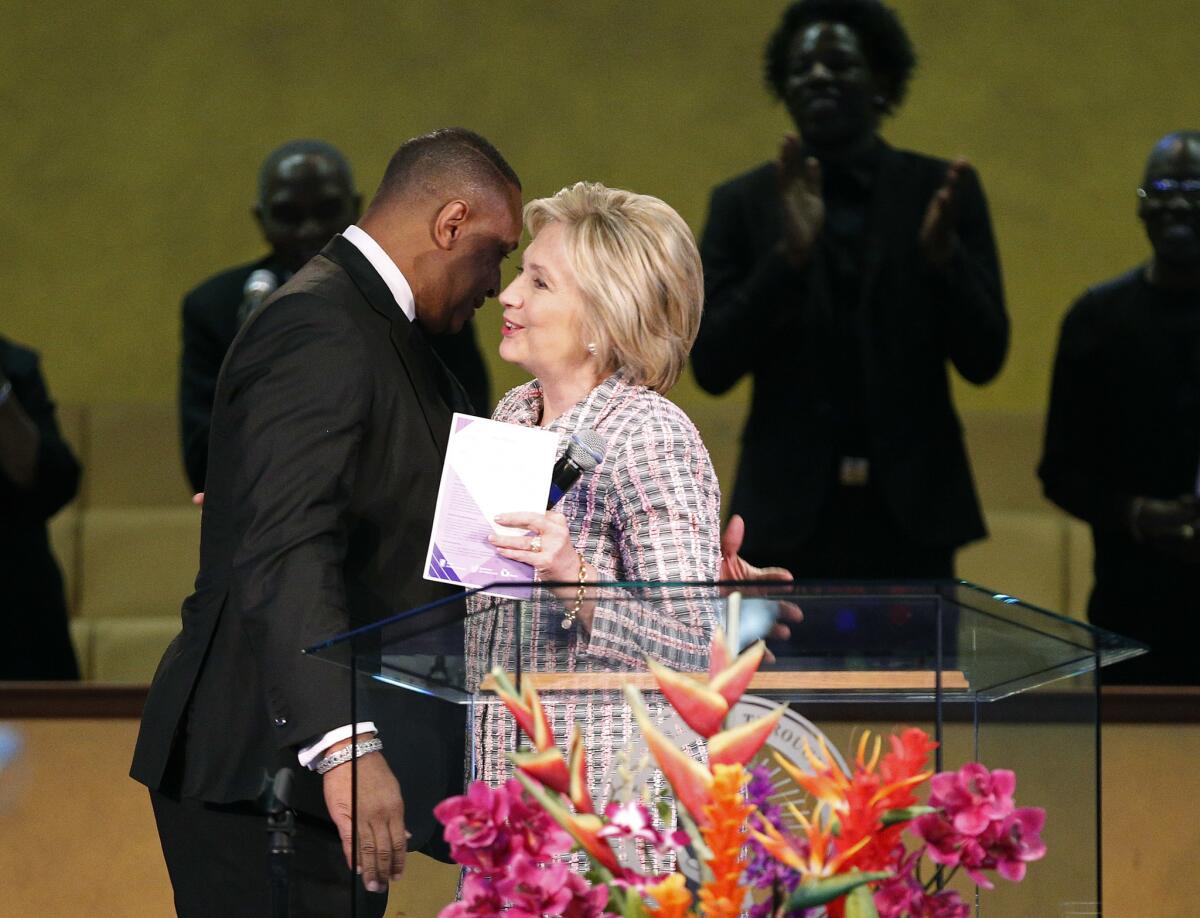 Hillary Clinton embraces Joseph Simmons, pastor of Oakland¿s Greater St. Paul Church, before speaking to the congregation on June 5, 2016.