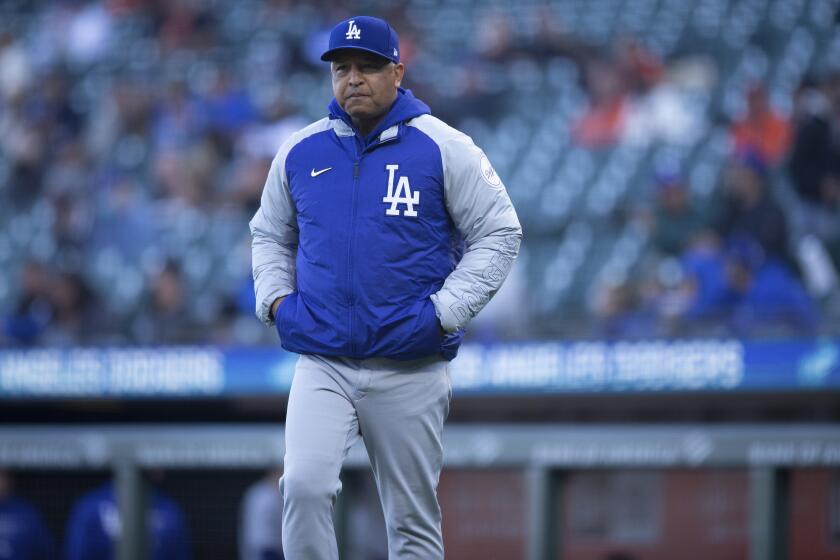 Los Angeles Dodgers manager Dave Roberts meets with umpires and San Francisco Giants manager Gabe Kapler to trade starting lineups before a baseball game, Friday, May 21, 2021, in San Francisco. (AP Photo/D. Ross Cameron)