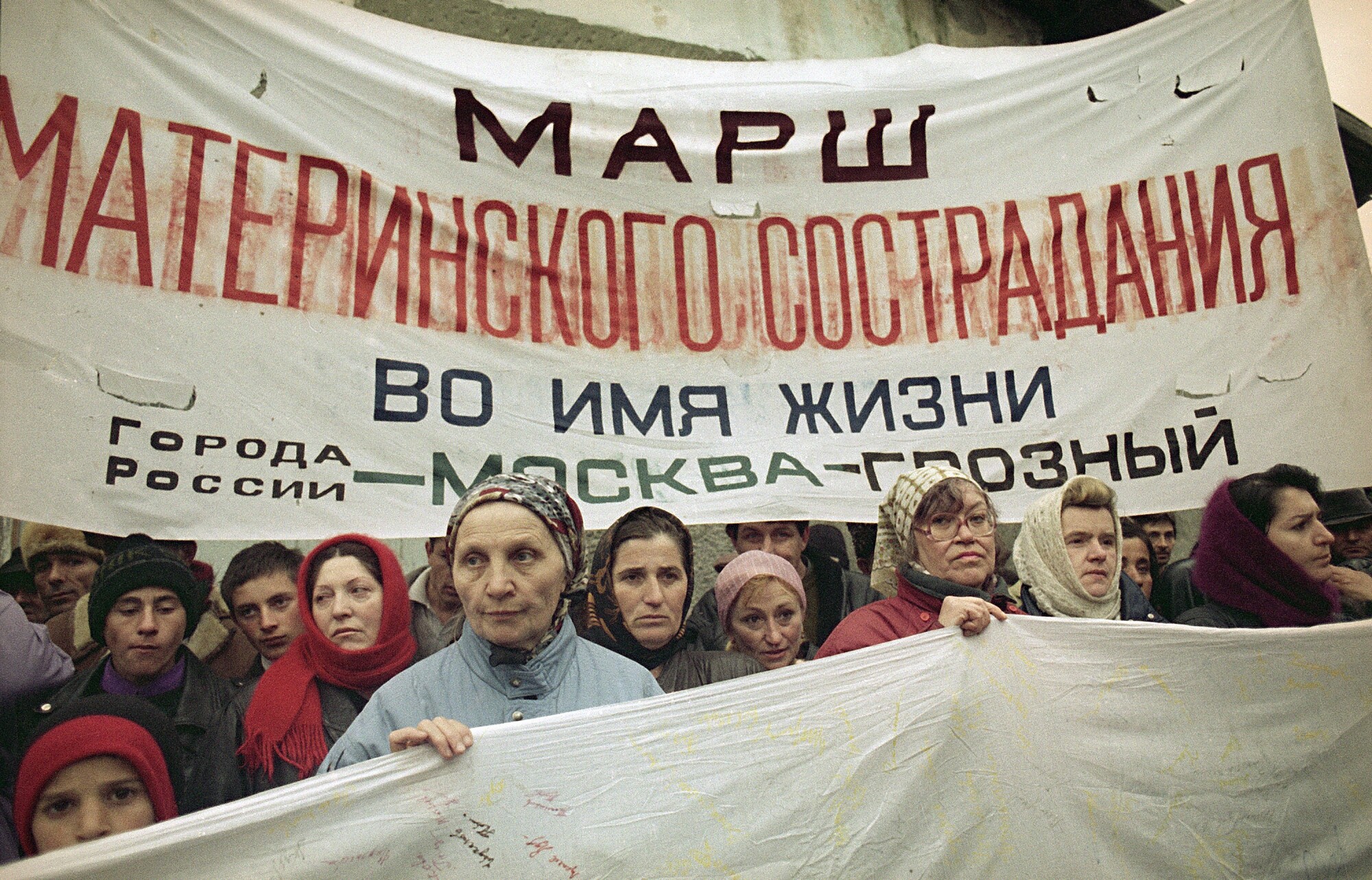 Mothers of Russian soldiers carry a protest banner in 1995. The banner says: "The March of Mothers' Compassion."