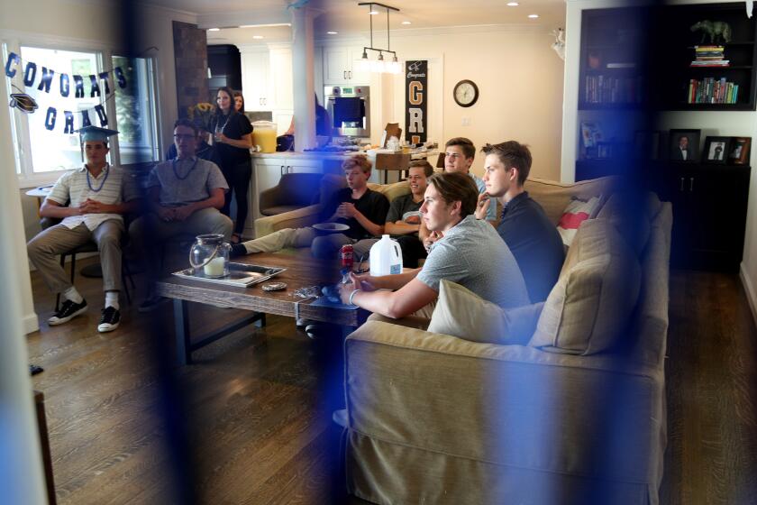 Seven Corona Del Mar High students watch their graduation ceremony live on television, sitting from left to right, Zach Green, Jack Mehoffer, Dylan O'Hearn, Aidan Pyne, Mason Gecowets, Nicholas Rottler and Luke Sullivan, at the Gecowets' home in Corona Del Mar on Thursday, June 18, 2020.