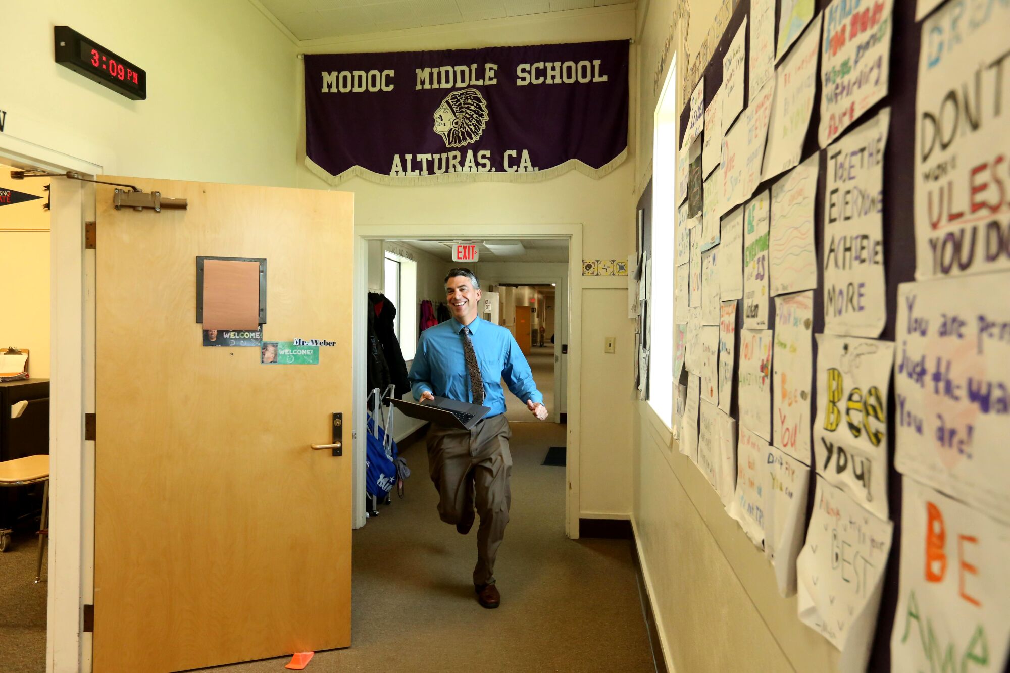 A man runs with a laptop toward a workshop at Alturas Middle School