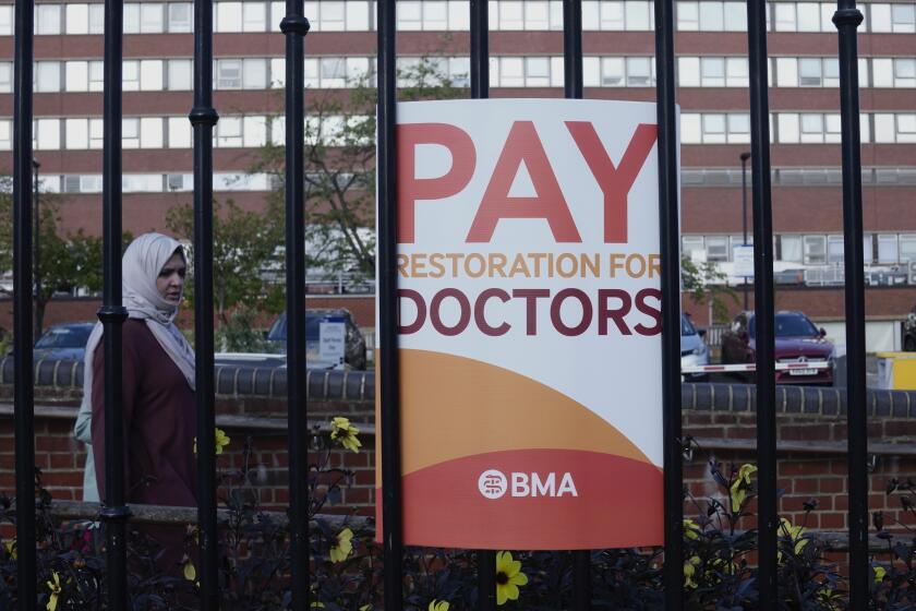 FILE - A placard from the BMA (British Medical Association) is displayed during a strike at St George's Hospital, in London, on Sept. 22, 2023. Senior doctors in England have accepted a pay offer from the British government that ends a year-long dispute with unprecedented strike action. The British Medical Association and the Hospital Consultants and Specialists Association, which represent so-called consultants, said Friday April 5, 2024 that 83% of those casting a vote backed the offer. (AP Photo/Kin Cheung, File)