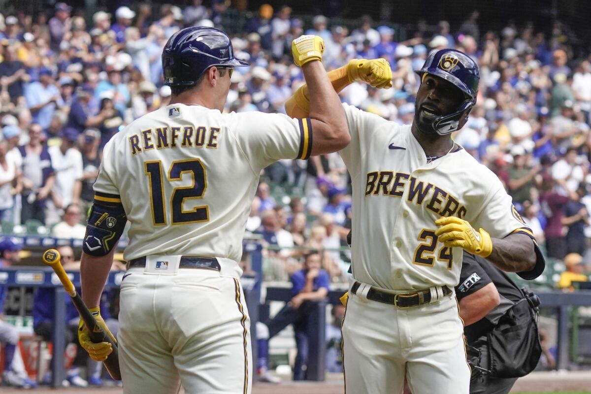 Milwaukee Brewers' Andrew McCutchen is congratulated by Hunter Renfroe after hitting a home run during the first inning of a baseball game against the Los Angeles Dodgers Thursday, Aug. 18, 2022, in Milwaukee. (AP Photo/Morry Gash)