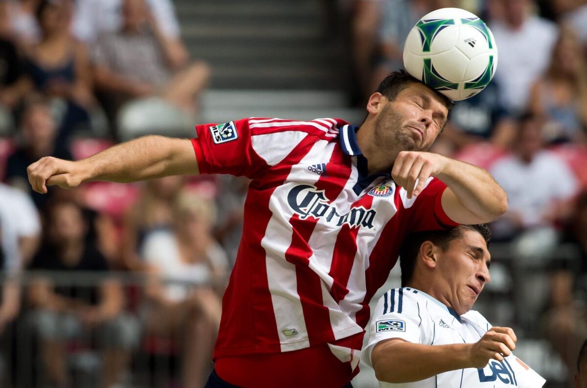 Chivas USA's Bobby Burling, left, heads the ball away from Vancouver's Johnny Leveron during a game earlier this month.