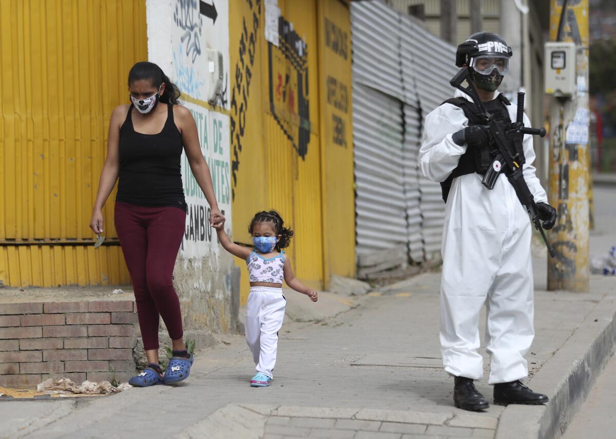 Un soldado con traje protector contra el coronavirus monta guardia en Bogotá.