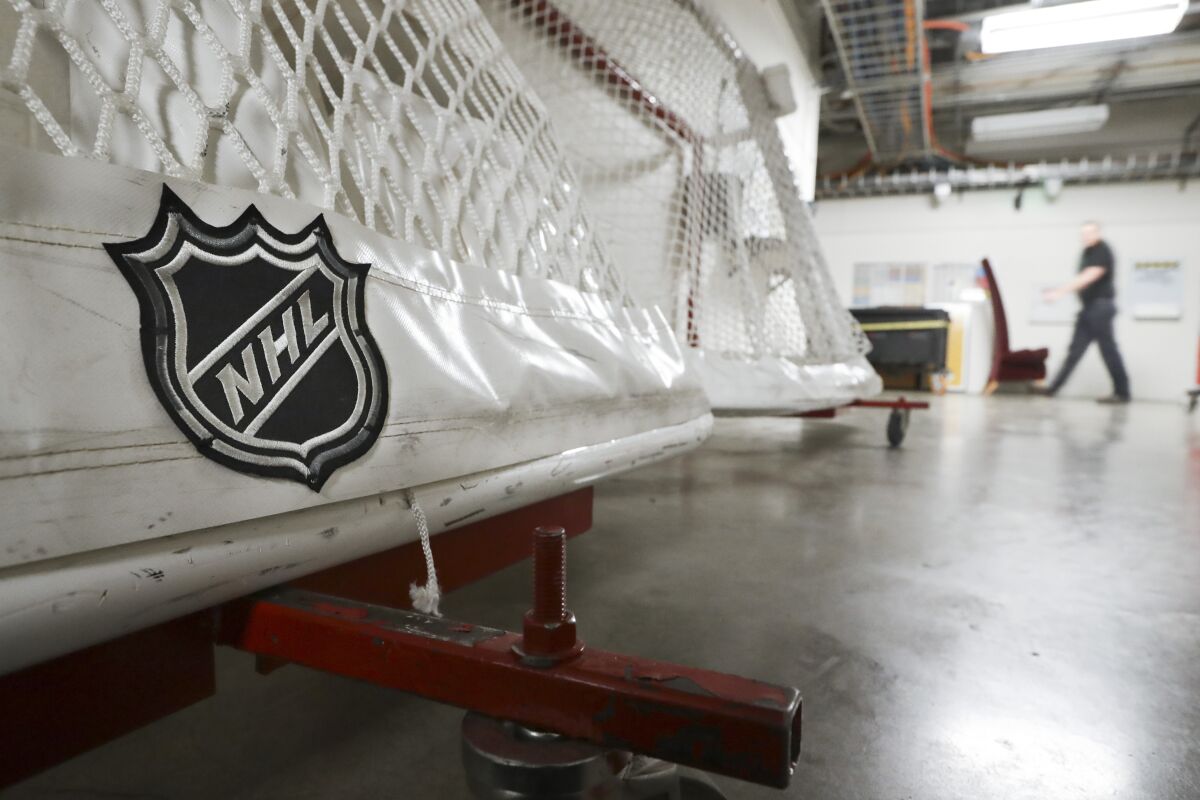 An NHL logo is shown on a hockey goal sitting on a concrete floor in a hallway.