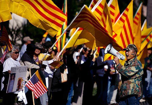 Hai Vu leads a chant in Santa Ana protesting against an exhibit that displayed artwork featuring symbols of Communist Vietnam. The protest came the day after one of the works was defaced with red paint and the owners of the building ordered the exhibit closed, saying the organizers lacked the proper business license.