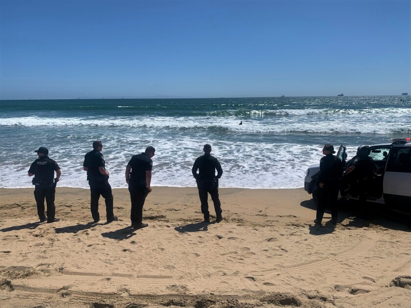  Police on shore at Bolsa Chica State Beach Saturday, after a robbery suspect tried to evade capture by swimming away.