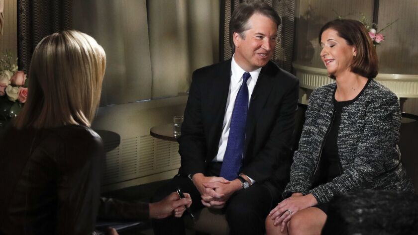 Brett Kavanaugh looks at his wife, Ashley Estes Kavanaugh, at the start of a Fox News interview with Martha MacCallum.