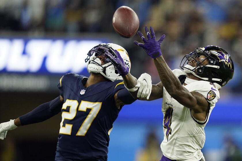 Los Angeles Chargers cornerback Essang Bassey (27) breaks up a pass intended for Baltimore Ravens wide receiver Zay Flowers (4) during the second half of an NFL football game Sunday, Nov. 26, 2023, in Inglewood, Calif. (AP Photo/Ryan Sun)