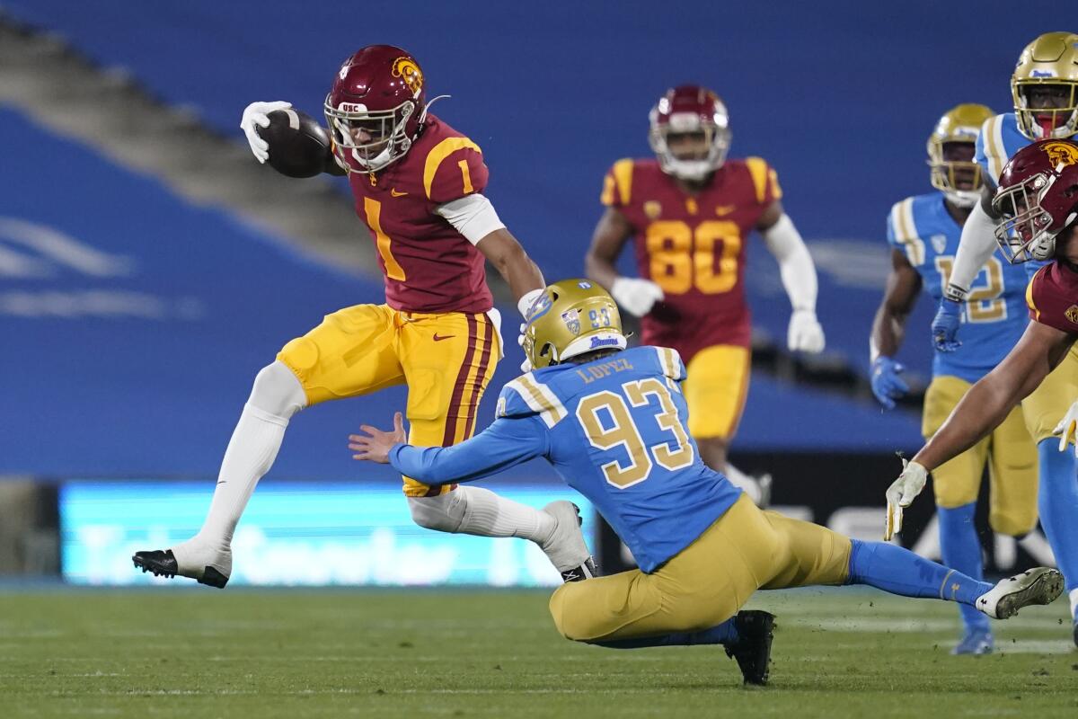 USC wide receiver Gary Bryant Jr. (1) avoids a tackle by UCLA kicker RJ Lopez (93) on Dec 12 in Pasadena. 