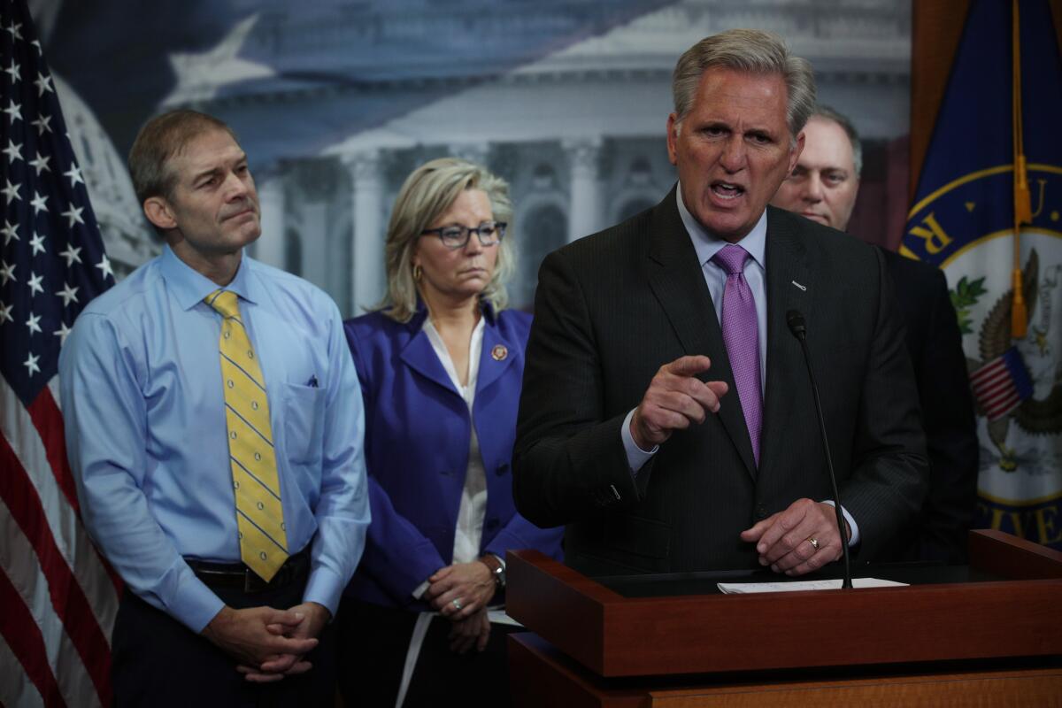 Kevin McCarthy speaking from a lectern with men and a woman behind him