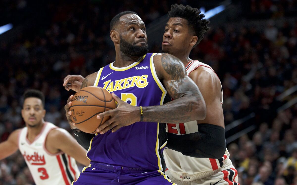 Lakers forward LeBron James drives down the lane against Trail Blazers center Hassan Whiteside during the first half of a game on Dec. 28, 2019, in Portland.
