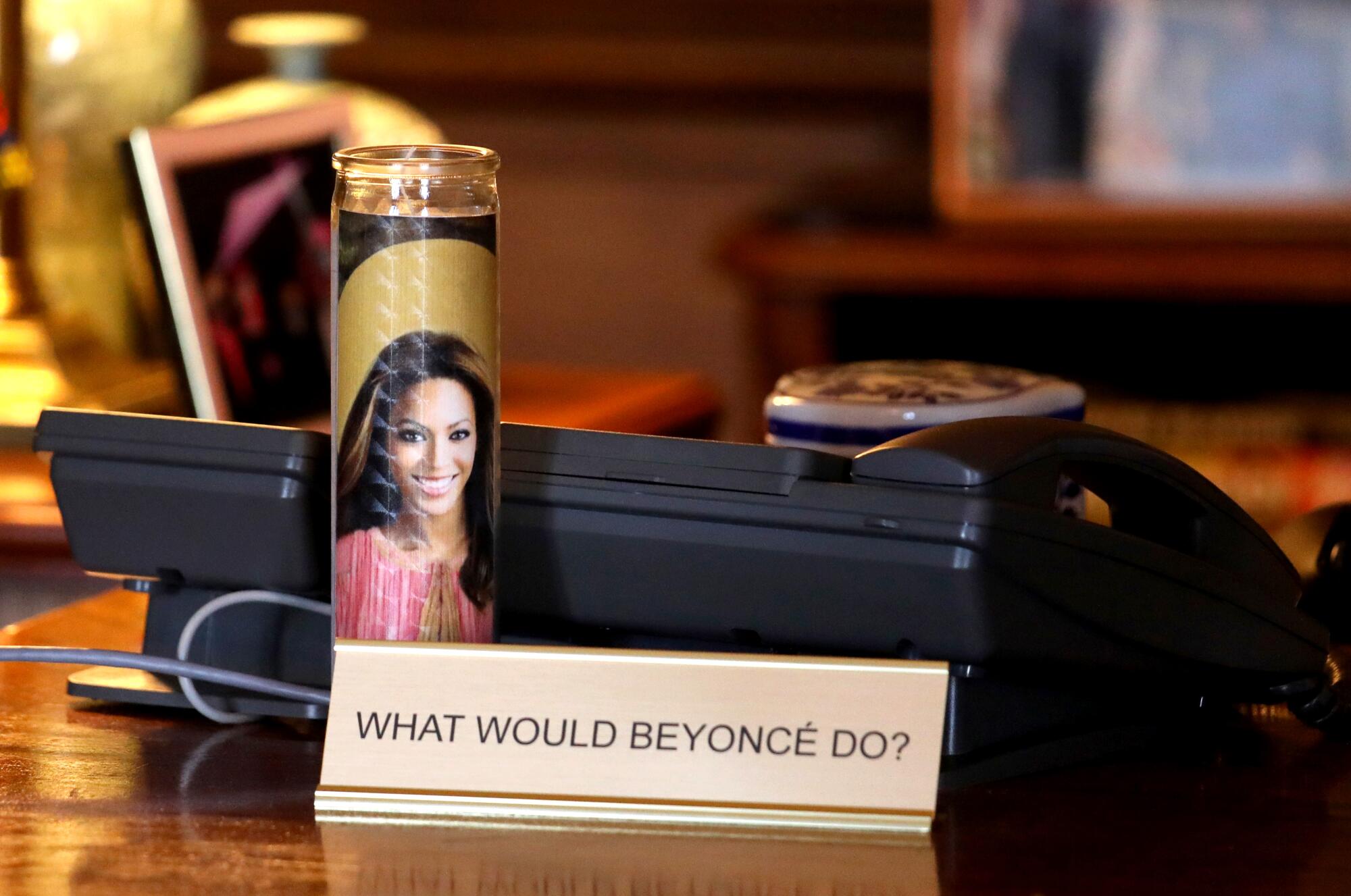 A votive candle of Beyonce on the desk of London Breed.