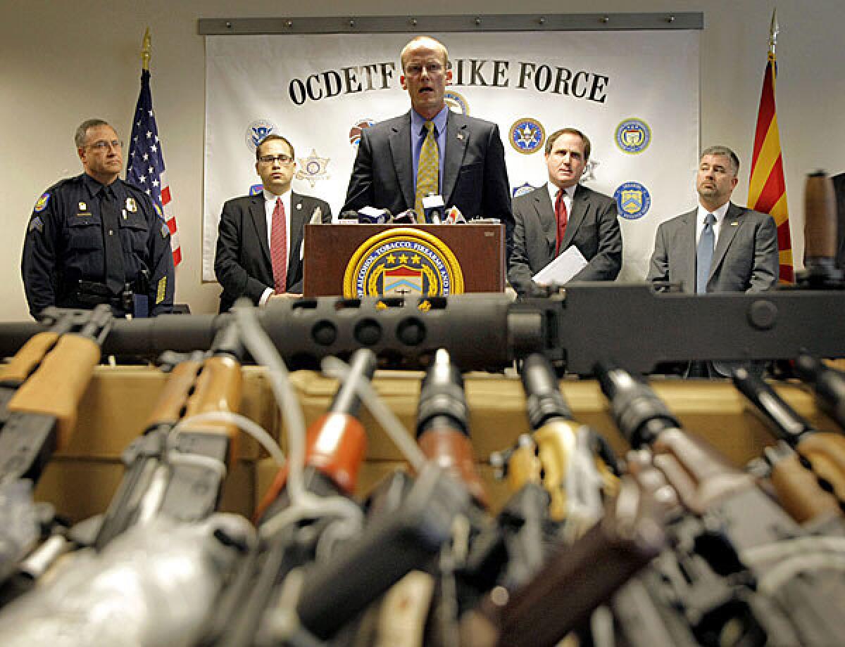 Bill Newell, special agent in charge of ATF Phoenix, speaks behind a cache of seized weapons in Phoenix. The ATF is under fire over a Phoenix-based gun-trafficking investigation called "Fast and Furious," in which agents allowed hundreds of guns into the hands of straw purchasers in hopes of making a bigger case.