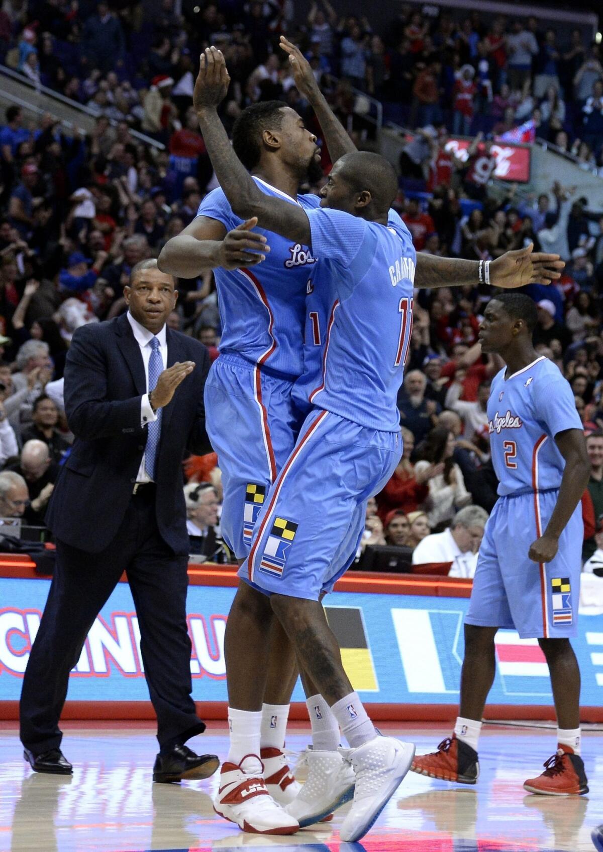 Clippers guard Jamal Crawford, right, is congratulated by teammate DeAndre Jordan after scoring the tying basket to send Sunday's game against the Minnesota Timberwolves into overtime. The Clippers went on to win in the extra period, 120-116.