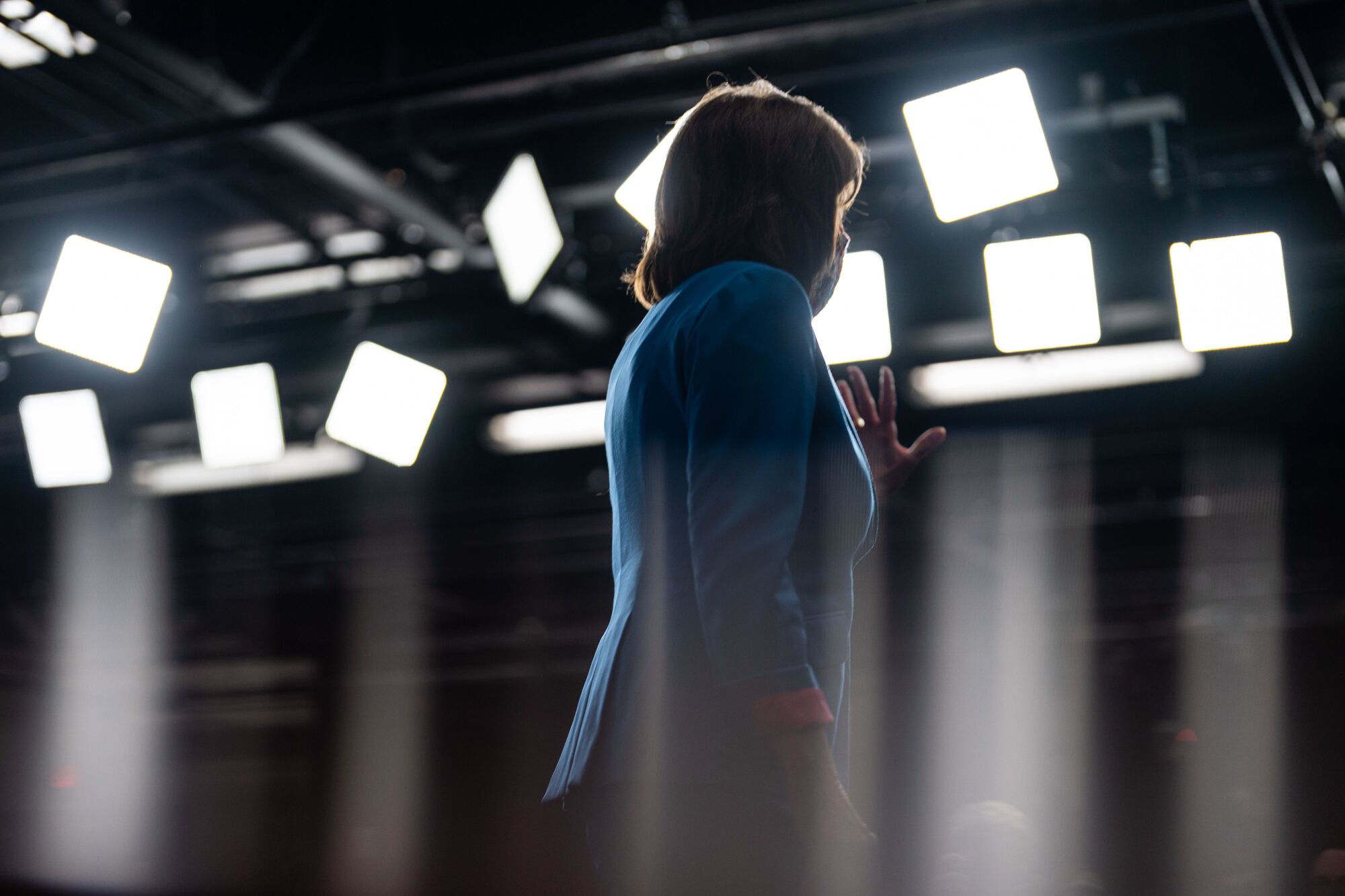 Nancy Pelosi is seen in silhouette in front of camera lights