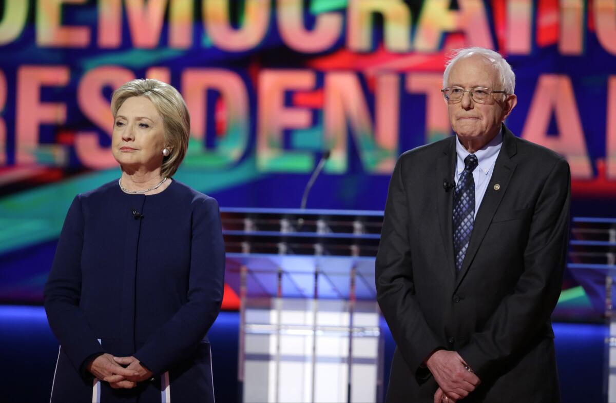Democratic presidential candidates Hillary Clinton and Bernie Sanders stand on stage before a primary debate at the University of Michigan-Flint in Flint, Mich. on March 6.