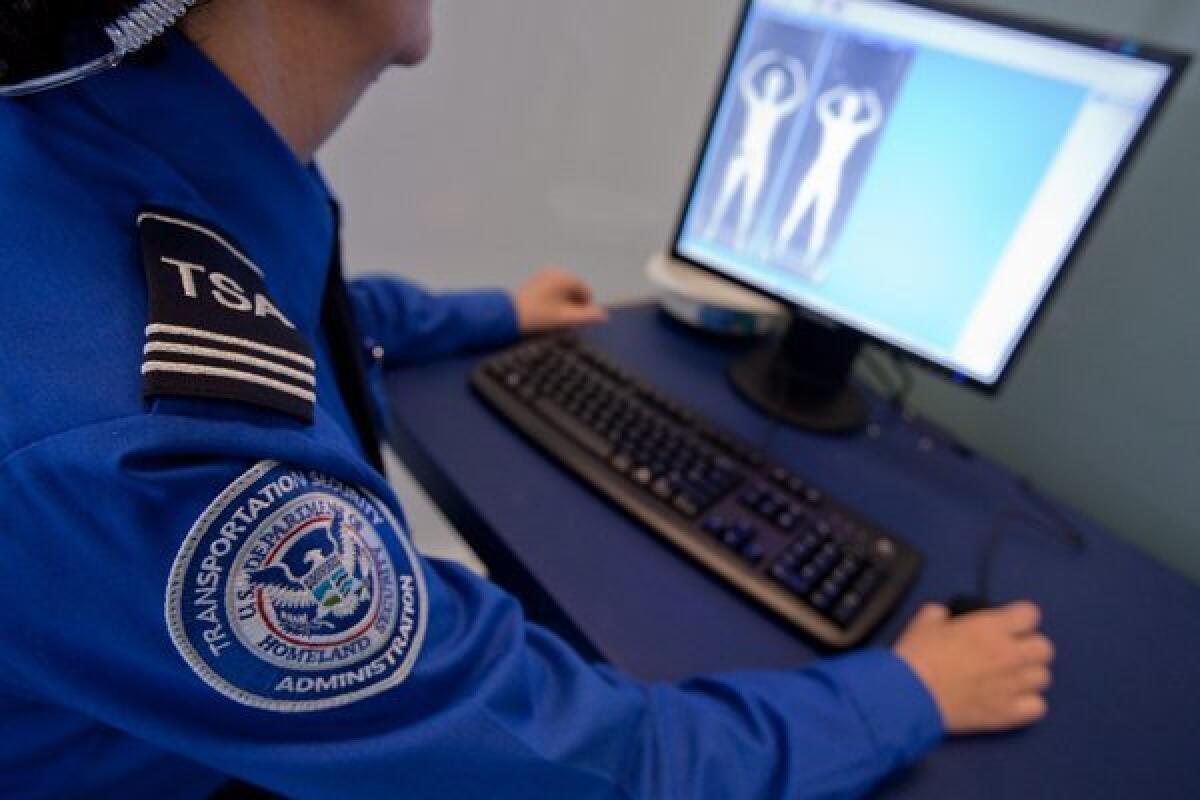 A Transportation Security Administration employee looks at an image from a full-body scanner during a demonstration for members of the media at Logan Airport in Boston.