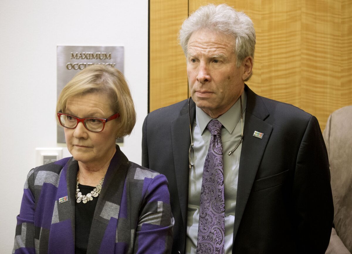 FILE - In this Jan. 29, 2016 file photo, Andy Parker and his wife, Barbara, listen as Virginia Gov. Terry McAulliffe announces a compromise on a set of gun bills at the Capitol in Richmond, Va. The family of a slain journalist is asking the Federal Trade Commission, Tuesday, Oct. 12, 2021, to take action against Facebook for failing to remove online footage of her shooting death. Andy Parker says the company is violating its own terms of service in hosting videos on Facebook and its sibling service Instagram that glorify violence. His daughter, TV news reporter Alison Parker, and cameraman Adam Ward were killed by a former co-worker while reporting for Roanoke, Virginia’s WDBJ-TV in August 2015. (AP Photo/Steve Helber)