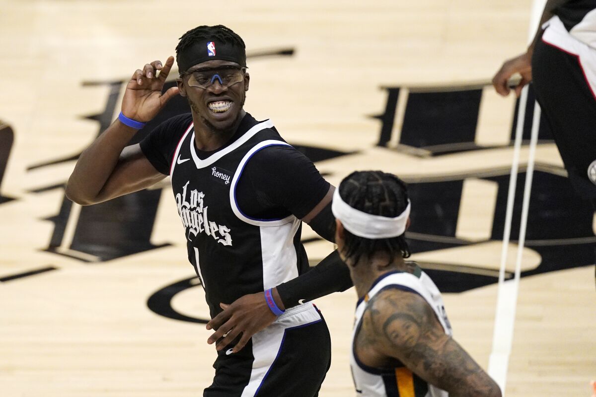 Los Angeles Clippers guard Reggie Jackson, left, smiles as Utah Jazz guard Jordan Clarkson after scoring during the second half of Game 3 of a second-round NBA basketball playoff series Saturday, June 12, 2021, in Los Angeles. (AP Photo/Mark J. Terrill)