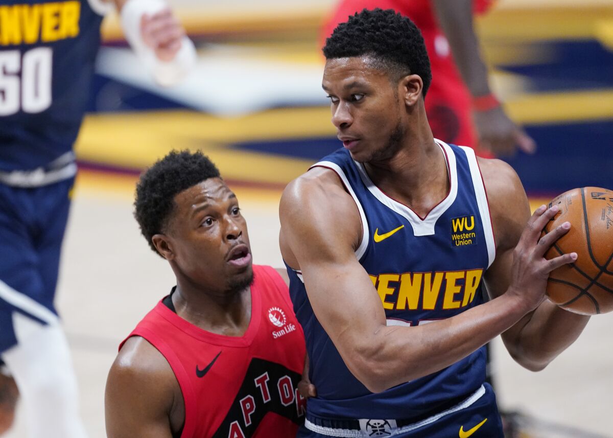 Denver Nuggets guard PJ Dozier, right, is trapped in the corner with the ball by Toronto Raptors guard Kyle Lowry in the first half of an NBA basketball game Thursday, April 29, 2021, in Denver. (AP Photo/David Zalubowski)
