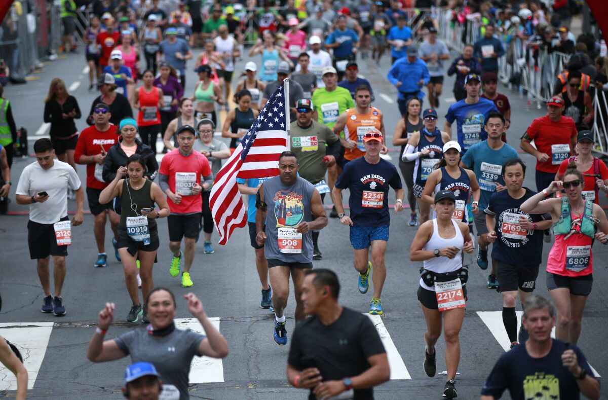 Melvin Coleman Jr. carried an American flag in the 2019 Rock 'n' Roll Marathon. This year's event has been postponed, with plans to reschedule to a still undetermined date in the fall.