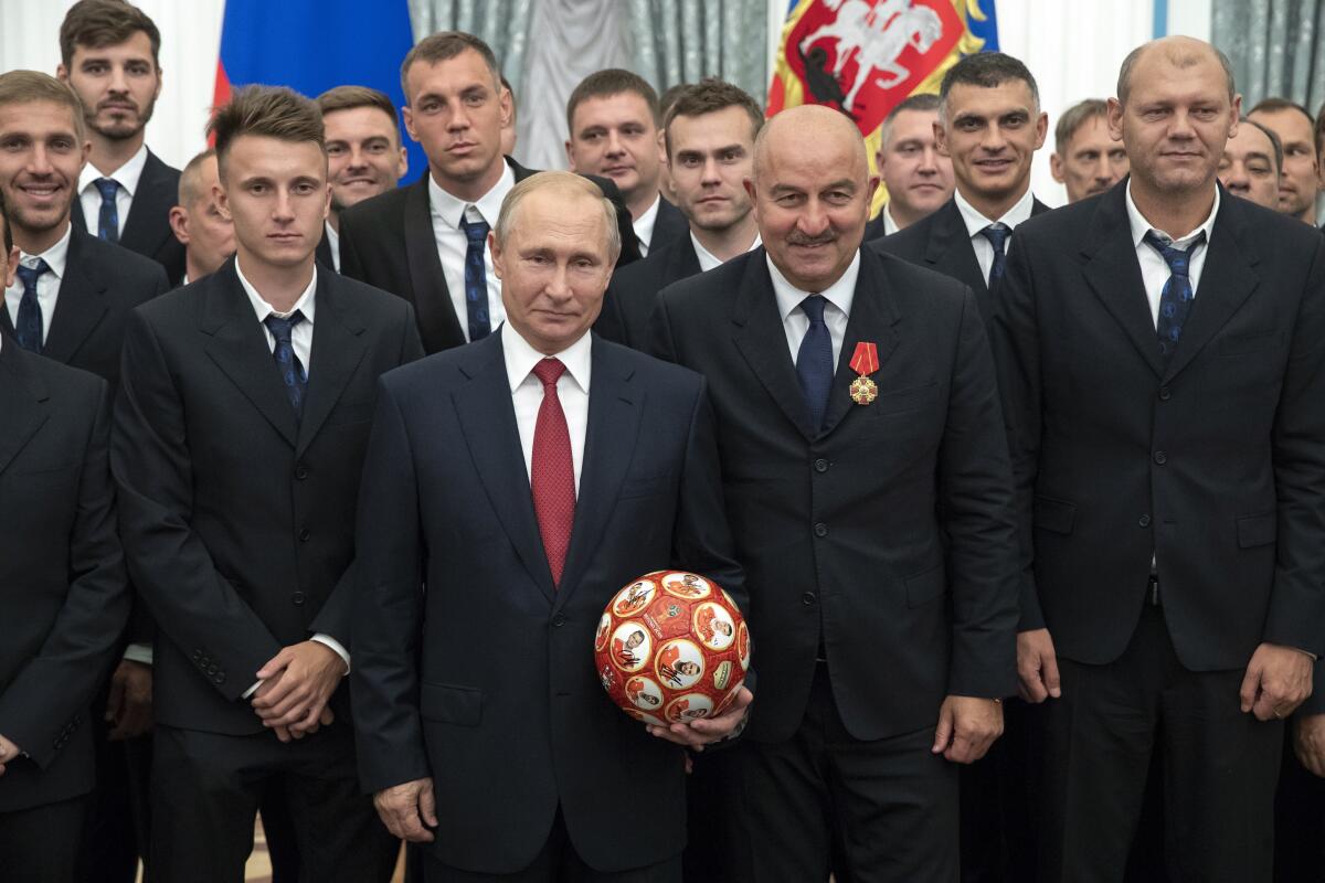 El presidente ruso Vladimir Putin (centro), el técnico de la selección de fútbol Stanislav Cherchesov 