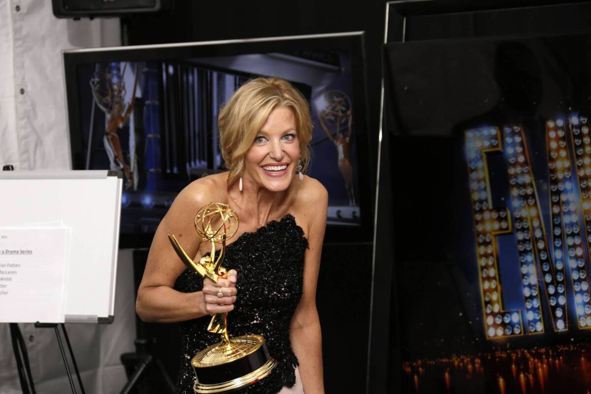 Anna Gunn happily grasps her Emmy for supporting actress in a drama series.