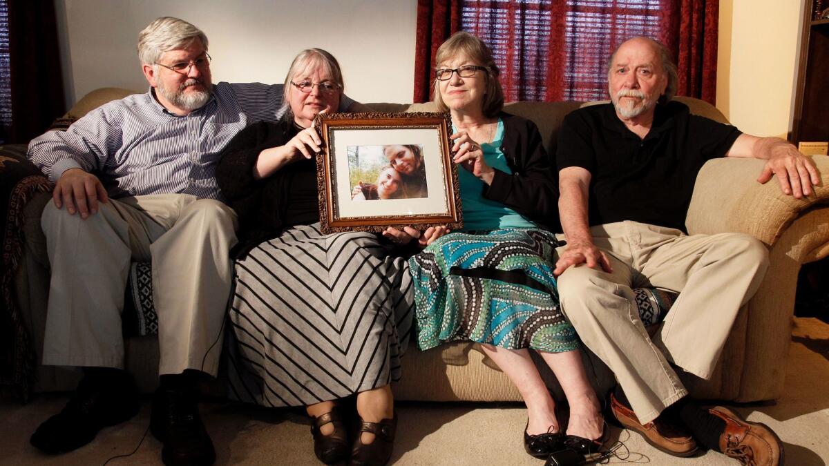 From left, Patrick Boyle, Linda Boyle, Lyn Coleman and Jim Coleman hold a photo of their kidnapped children, Joshua Boyle and Caitlan Coleman, on June 4, 2014.