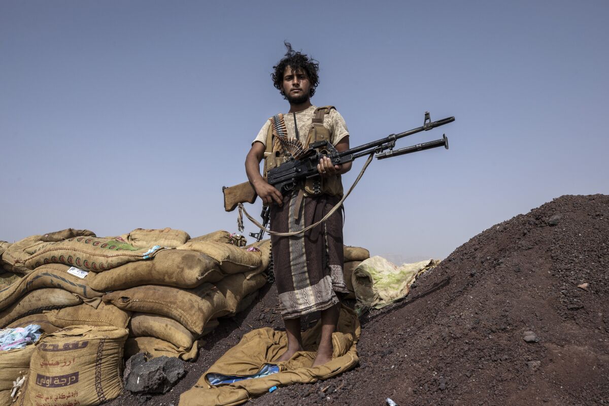 Yemeni fighter Hassan Saleh backed by the Saudi-led coalition stands for a photograph after clashes with Houthi rebels on the Kassara front line near Marib, Yemen, Sunday, June 20, 2021. Saleh and his younger brother Saeed, both in their early 20s, both in their early 20s, have been fighting alongside other government fighters and tribesman outside the oil-rich city of Marib against the months-long offensive by the Iranian-backed rebels. They say they need more weapons to push the attackers back. (AP Photo/Nariman El-Mofty)