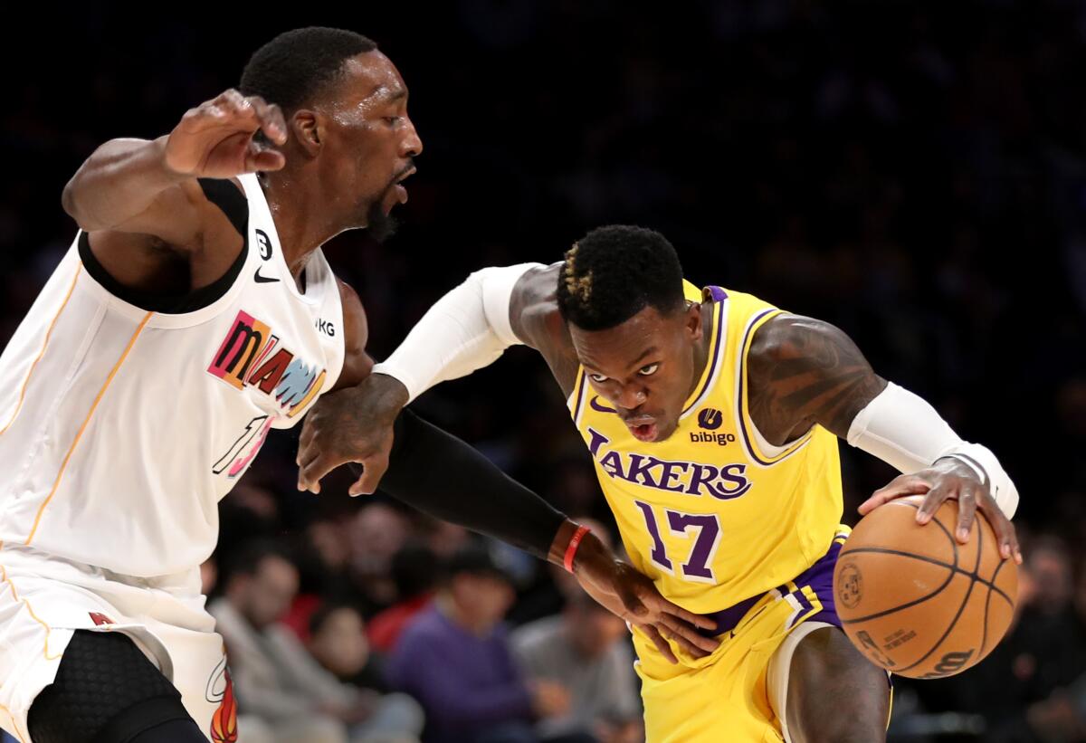 Lakers guard Dennis Schroder, right, drives to the hoop past Heat center Bam Adebayo