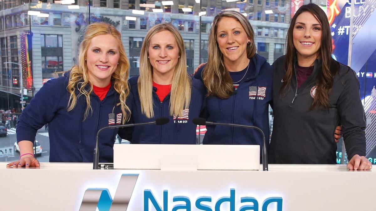 U.S. women's hockey players Jocelyne Lamoureux-Davidson, Monique Lamoureux-Morando, Meghan Duggan and Hilary Knight pose for a photo at NASDAQ headquarters in New York on Feb. 8.