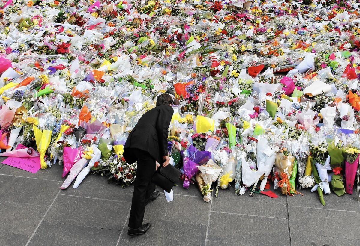 A man places flowers for the victims of the cafe attack in Sydney, Australia, on Dec. 16.
