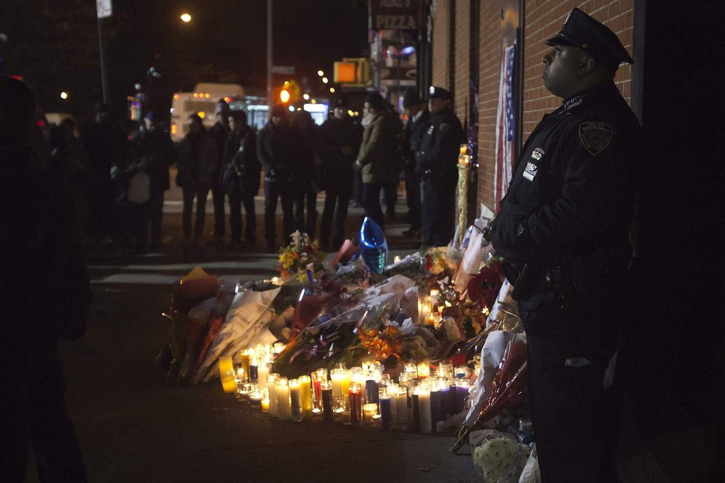 Police stand solemn vigil late at night at a makeshift memorial at the site where two police officers were shot in the head in the Brooklyn borough of New York