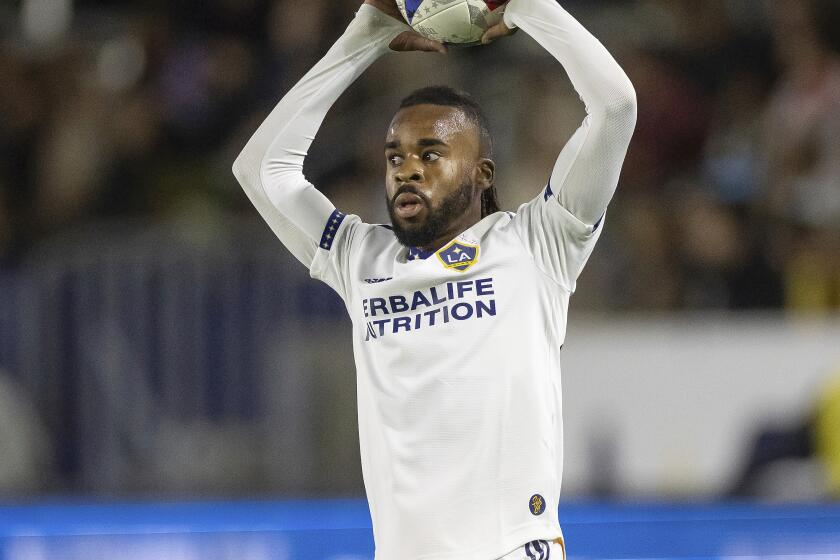 LA Galaxy's Raheem Edwards raises the ball above his head and prepares to throw it in